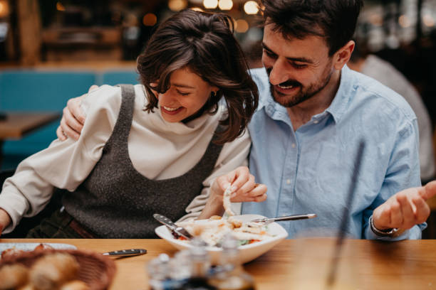 istock Photograph the two individuals engaging in conversation, smiling, or sharing a light-hearted moment while enjoying their meal 1500773348