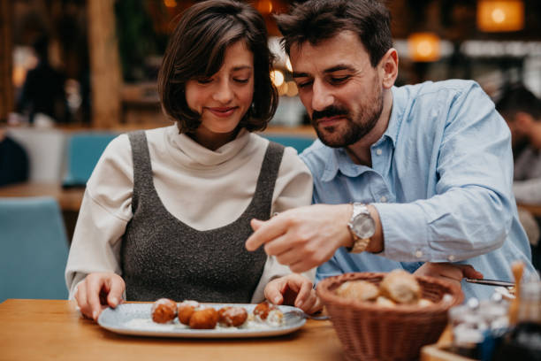 istock Photograph the two individuals engaging in conversation, smiling, or sharing a light-hearted moment while enjoying their meal 1500773354