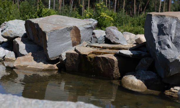 istock A small mountain stream flows down from large stones. The brook flows into a small reservoir over huge granite stones. Summer beautiful mountain stream. 1500773689