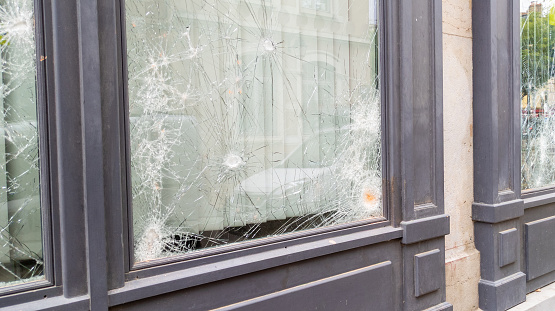 Broken shop impact of stone and hammer on facade store window