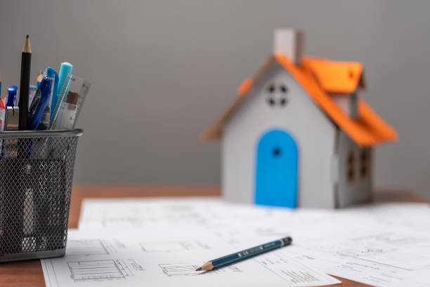 istock Architectural blueprints document and house model marked by measurements and construction and design details. 1500780723