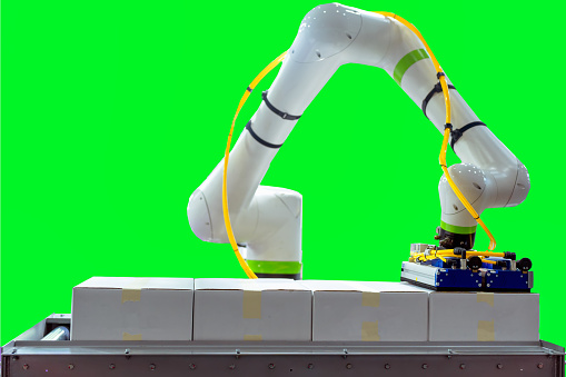 Robotica arm picking the paper box on the automated conveyor system in green screen background.