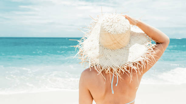 istock Woman on the beach with a white hat 1500781262