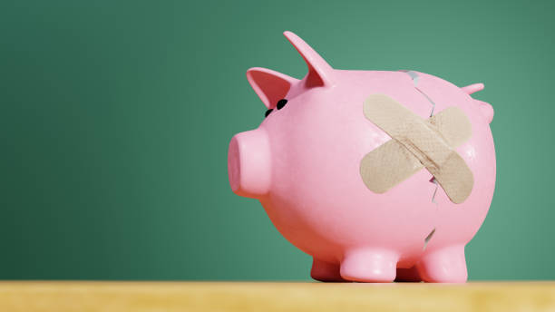 grieta de alcancía rosa con una curita - adhesive bandage currency finance repairing fotografías e imágenes de stock