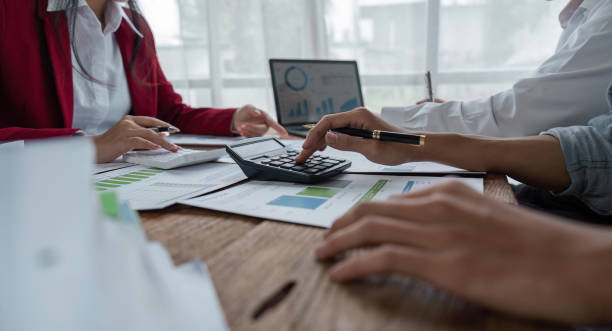 Team Of Business working at office with documents on his desk, doing planning analyzing the use a financial calculator, business plan investment, finance analysis concept