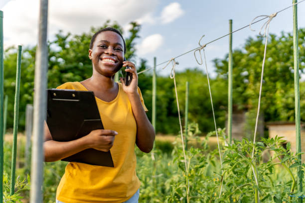 istock Young woman using a mobile phone on her farm 1500793553