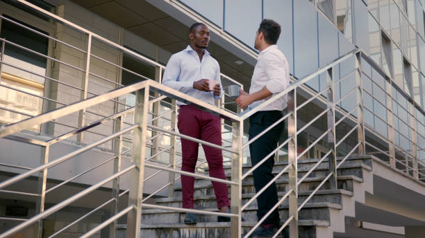 istock Diverse business colleagues having conversation during coffee break standing on stairs outdoors 1500793599