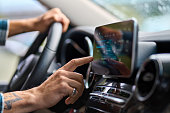 Man traveler sitting in car using gps navigation on monitor while driving.