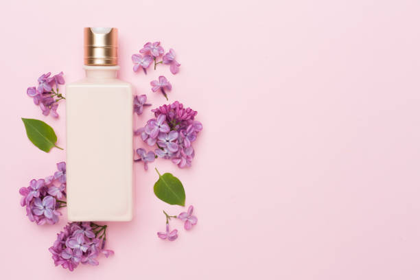istock Composition with cosmetic bottle and flowers on color background, top view 1500798430