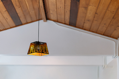 The golden light pendant ceiling lamp has a square iron frame in a modern shape. Home decoration ideas.