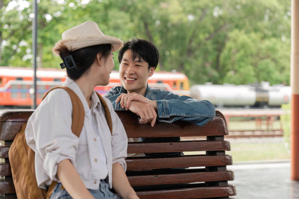 istock Asian couple chatting while waiting for train to arrive 1500801738