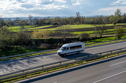 Modern comfortable tourist bus driving through highway. Travel and coach tourism concept. The world's best transport of goods.