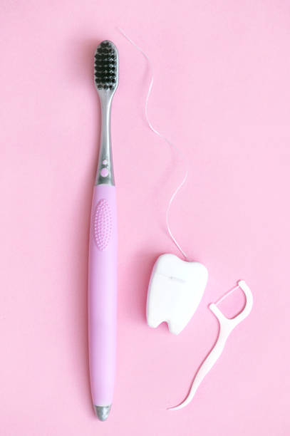 brosse à dents avec cure-dent en plastique avec soie dentaire et soie dentaire sur fond rose photo verticale - 7679 photos et images de collection
