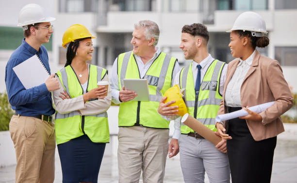 istock Construction site, team and meeting at a building for planning, creative and collaboration. Architecture, business people and designer group with blueprint, documents and engineering development plan 1500804044