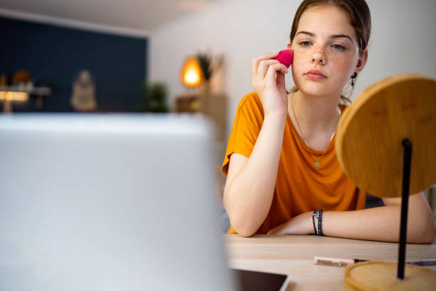 istock Teenage girl doing make-up at home while watching make-up tutorial on her laptop 1500804145