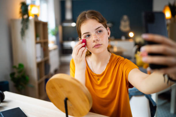 istock Teenage girl taking selfies while doing make-up at home 1500804870