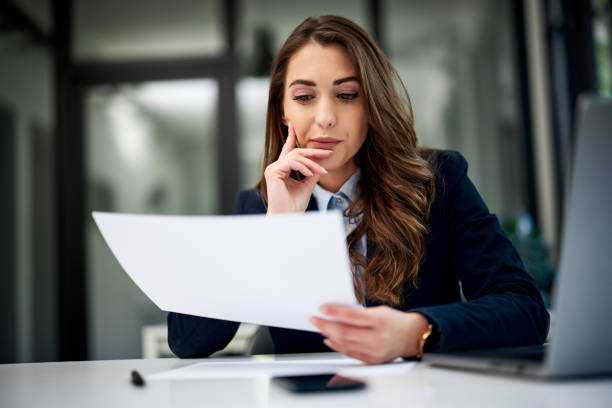 istock A serious female employee reading a business document at the office. 1500807597