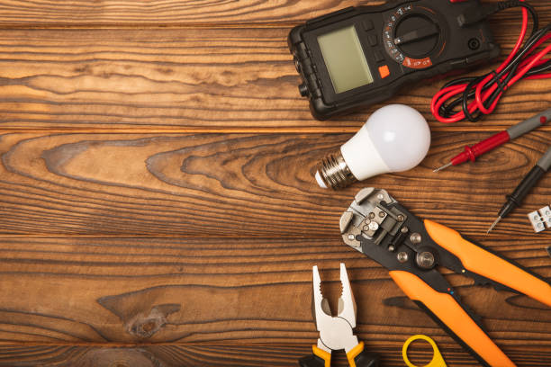 istock Electrician equipment on brown background with copy space.Top view.Electrician tool set.Multimeter, tester,screwdrivers,cutters,duct tape,lamps,tape measure and wires.Flet lay. 1500807599