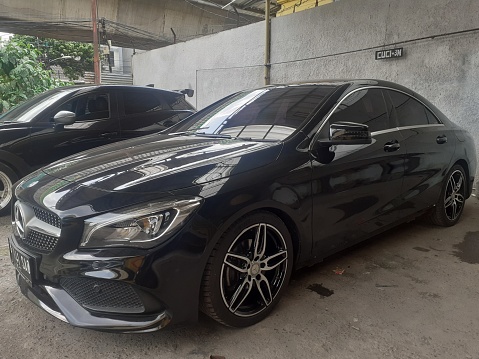 Jakarta, Indonesia, June 20, 2023 : You can see a black Mercedes-Benz Cla200  sedan parked in the yard of the insurance, service and body repair workshop, after work on the car was finished.