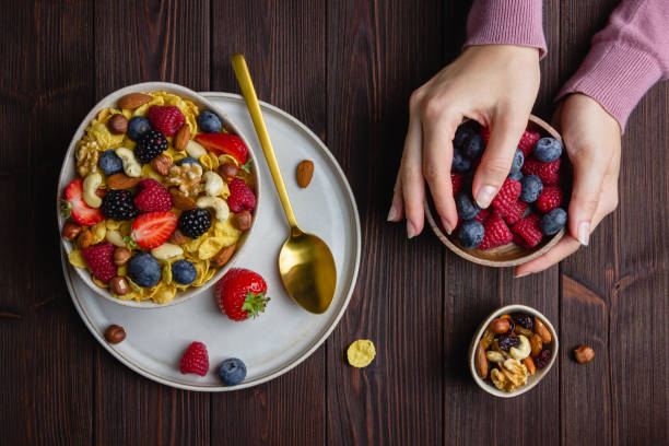 Corn flakes with berries and nuts in bowl