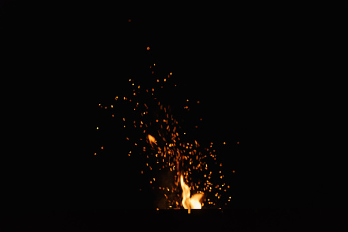 firecamp sparks over night sky, black background