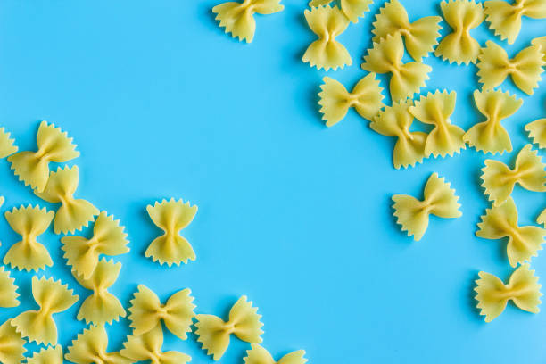 istock Raw pasta farfalle with copy space on blue background 1500813158