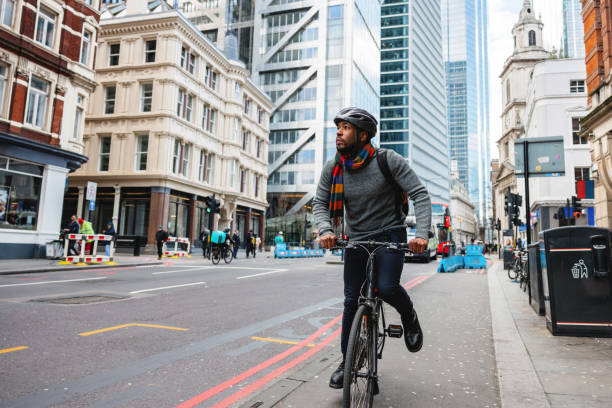 dorosły czarny mężczyzna w kasku na rowerze do swojego biura w mieście - bicycle london england cycling safety zdjęcia i obrazy z banku zdjęć