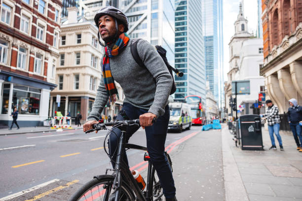 dorosły czarny mężczyzna w kasku na rowerze do swojego biura w mieście - bicycle london england cycling safety zdjęcia i obrazy z banku zdjęć