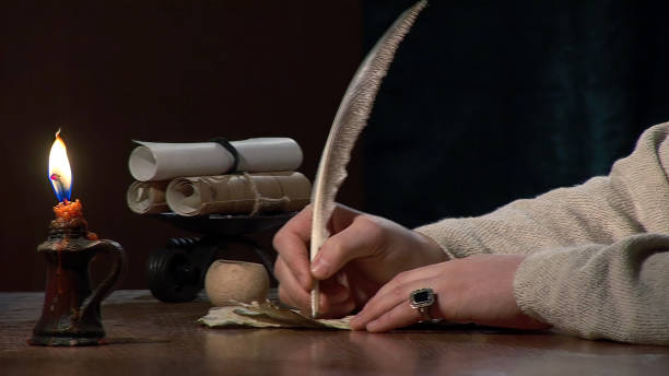 istock Old letter - a man hand writing by candlelight 1500818159