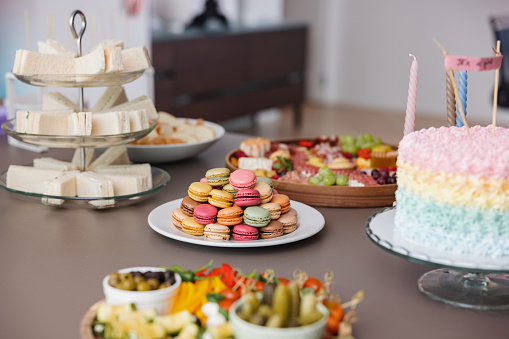 A set table before a baby shower celebration. Cute and colorful snacks for the guests on a dining table.