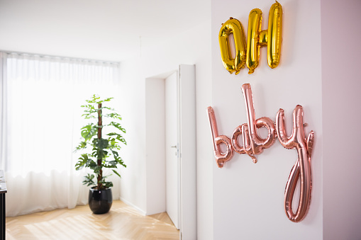 'Oh Baby' balloon decoration at a modern apartment before a baby shower celebration.
