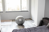 Fitness ball near window on floor in spacious room. Healthy lifestyle concept.