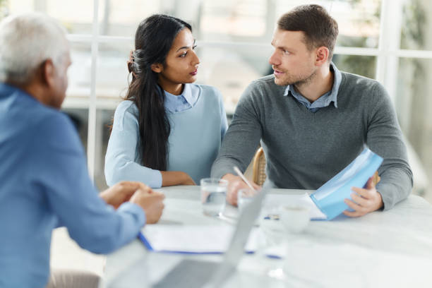 istock Young couple talking on a meeting with their agent. 1500822356