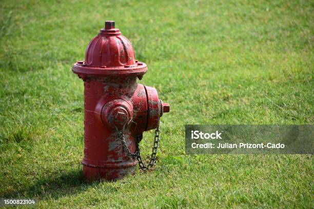 Red Worn Fire Hydrant In Urban Neighborhood Park Grass Stock Photo - Download Image Now