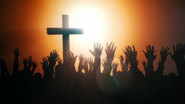 istock Praying hands with a dark cross 1500825299