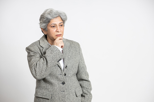 Mature senior indian woman thinking gesture isolated on white studio background, concerned Asian Middle aged businesswoman,60s gray-haired lady executive business leader manager.