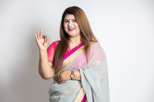 Happy Indian woman wearing saree hand with awesome or good expression isolated on white background. overweight or fat lady smiling. Zero percent interest concept.