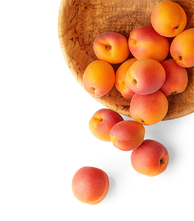 Fresh apricots in the wooden bowl still life of ripe fruits. Apricot Fruits isolated on white background. Vegan organic healthy food stillife