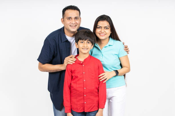istock Happy young attractive indian family looking at camera isolated on white studio background. Smiling urban asian parents standing with little kid son. 1500837583