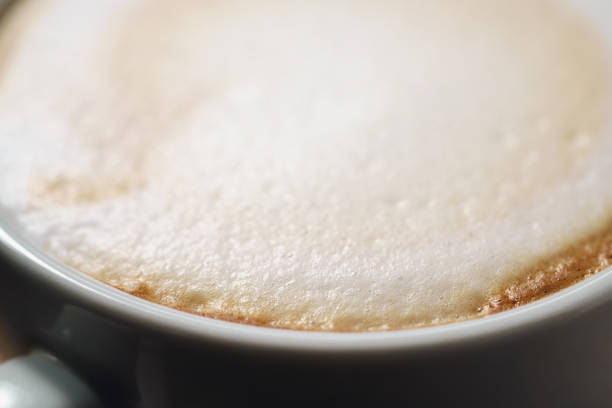 closeup fresh cappuccino with chocolate flakes on wood table, shallow focus