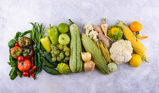 Assortment of green vegetables and fruits on green background