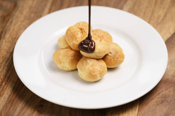 istock pour chocolate on profiteroles on plate closeup 1500843067