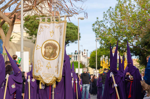 ALMERIA, SPAIN - APRIL 06, 2023 Procession of people in the holy week. Residents participating in the procession wear platforms with images of saints