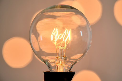 Incandescent light bulb with bokeh on background.
