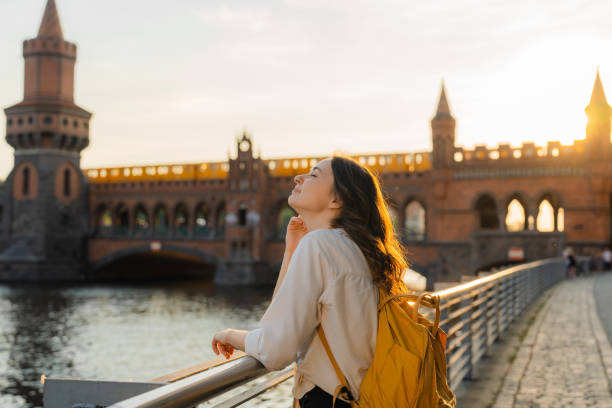 woman walking in berlin at sunset near oberbaumbrucke bridge - oberbaumbrücke fotos stockfoto's en -beelden