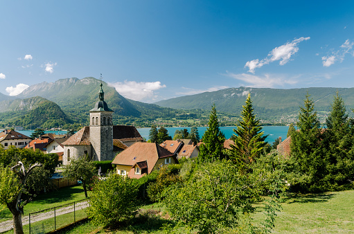 Charming Alpine village with church and Lake Annecy