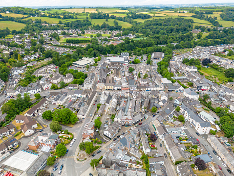 Okehampton, UK. 22 June 2023. View over the high street and centre of Okehampton in Devon with shops and cars.
