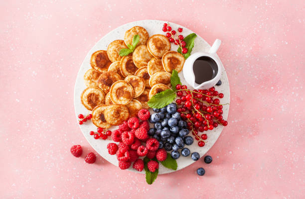 american mini pancake board with berries and maple syrup