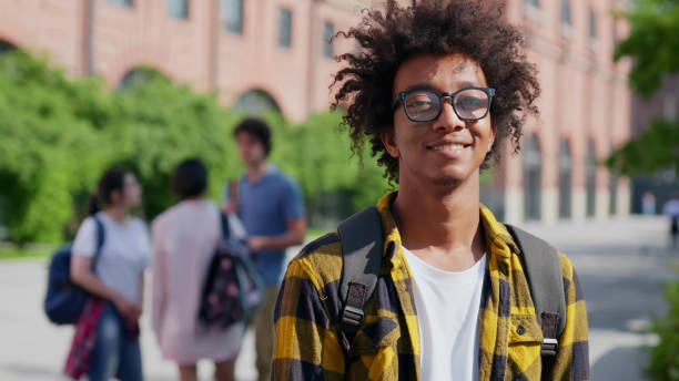 istock Medium shot of handsome african college student with backpack and glasses outdoors at campus 1500864803