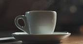 steam rising from espresso cup with fresh hot coffee shallow focus